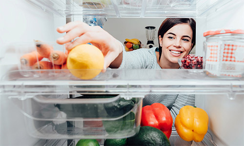 Woman Reaching into Refrigerator